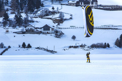 Man kiteboarding on snow covered field