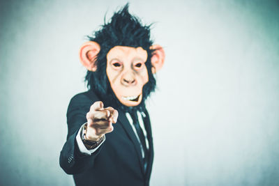 Man wearing monkey mask against white background