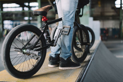 Young male staying with his bike on the ramp. unrecognizable bmx rider