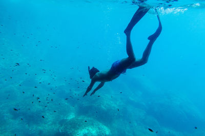 Shirtless young man scuba diving in sea