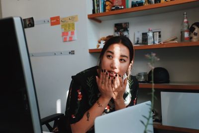 Young woman sitting with laptop and computer at office