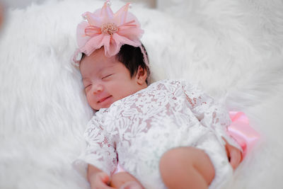 Cute newborn baby sleeps on white fluffy coverlets