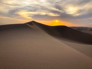 Scenic view of desert against sky during sunset