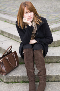 Portrait of woman with purse sitting on steps