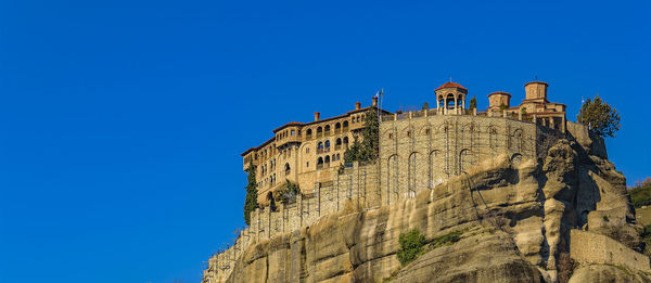 Low angle view of rock formations against clear blue sky