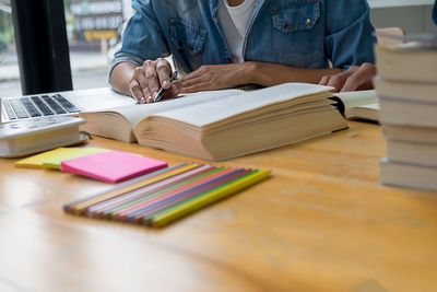 Midsection of woman working on book