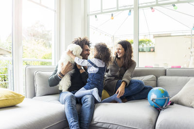 Friends sitting on sofa at home