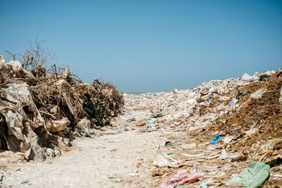 Garbage at beach against clear blue sky