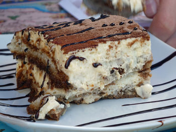 Close-up of hand holding ice cream in plate