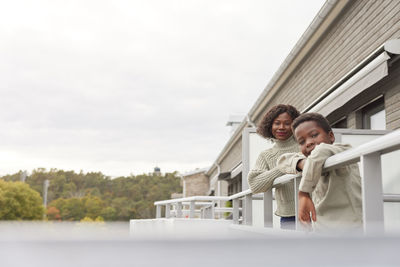 Portrait of mother and son standing on balcony