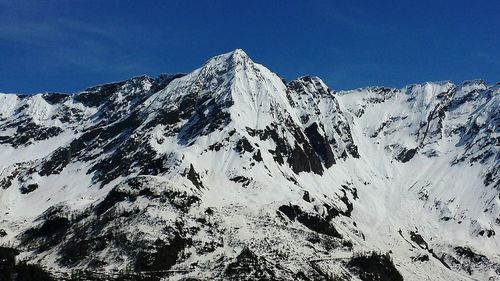 Scenic view of snowcapped mountains against cloudy sky