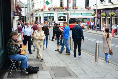 Group of people on footpath in city