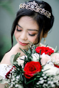 Portrait of young woman with red rose