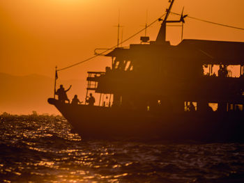 Silhouette ship sailing on sea against sky during sunset