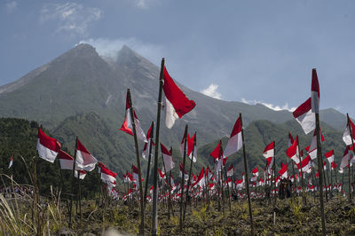 Red flags on mountain against sky