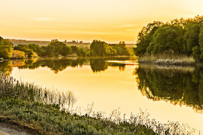 Scenic view of lake against sky at sunset