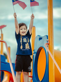 Full length of boy standing on slide at playground