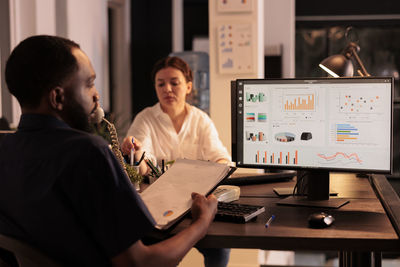 Midsection of man using laptop at table