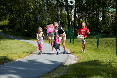 Siblings jumping over road in city