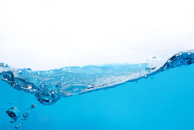 Close-up of water splashing against blue background