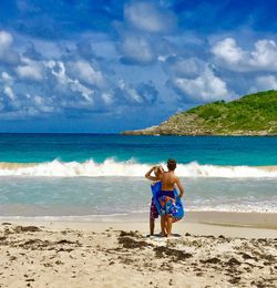 Boys playing on beach against sky