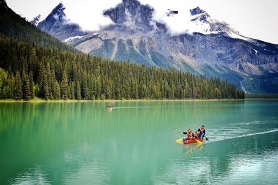 People canoeing at countryside lake