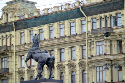 Low angle view of statue against building in city