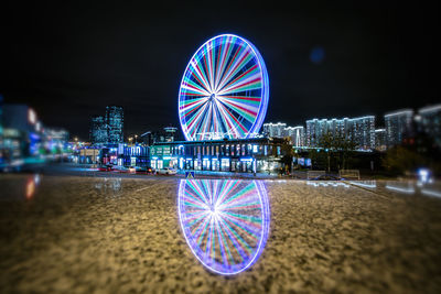 Illuminated ferris wheel at night