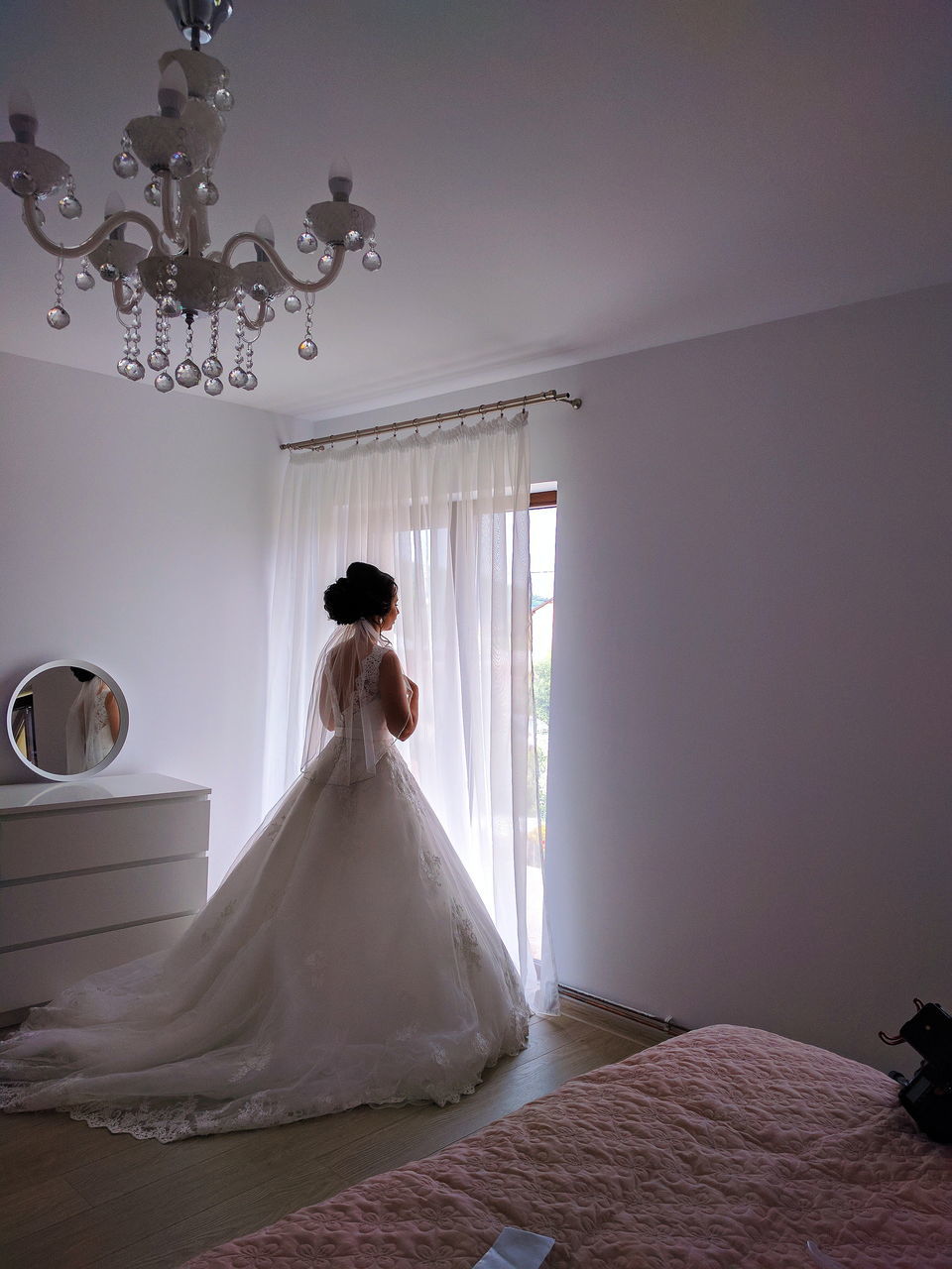 bride, wedding dress, wedding, life events, white color, indoors, one person, women, anticipation, real people, standing, wedding ceremony, elegance, celebration, veil, full length, ceremony, bouquet, day, groom, bridal shop, young adult, adult, people