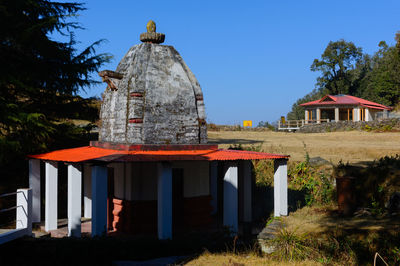 Gazebo by building against clear blue sky