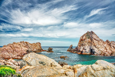 Rocks on sea shore against sky