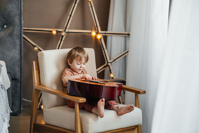 Little boy playing classical guitar. high quality photo