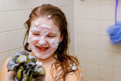 Close-up of girl bathing in bathroom