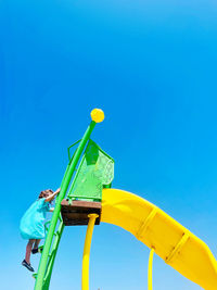 Low angle view of umbrella against clear blue sky