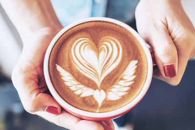 Close-up of hand holding coffee cup