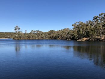 Scenic view of lake against clear blue sky