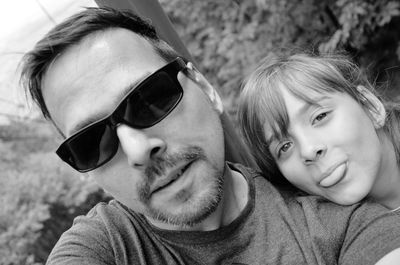 Father with playful daughter against plants at forest