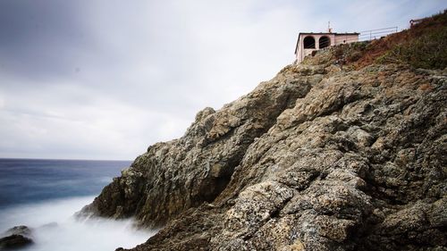 Rock formation on sea against sky