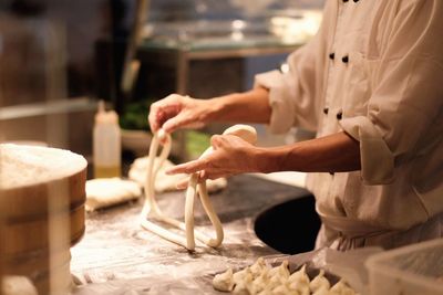 Midsection of chef preparing food in kitchen