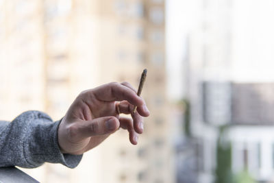 Close-up of hand holding cigarette