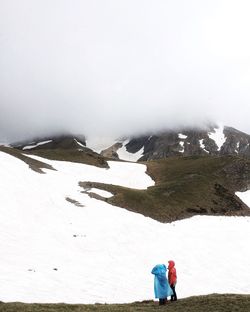 Rear view of people on snow against sky