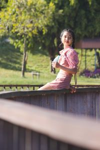 Portrait of a smiling young woman sitting outdoors