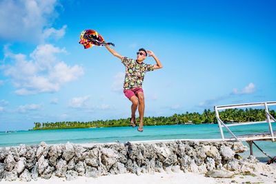 Man jumping at sea pool against sky