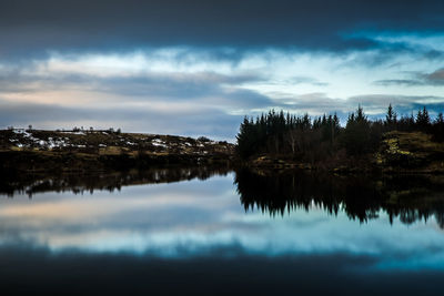 Reflection of trees in lake against sky