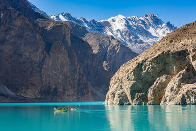 Boats in lake against mountains and sky