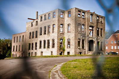 Building by road in city against sky