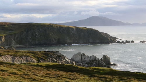 Scenic view of sea and mountains against sky