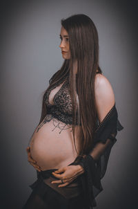 Young woman standing against wall