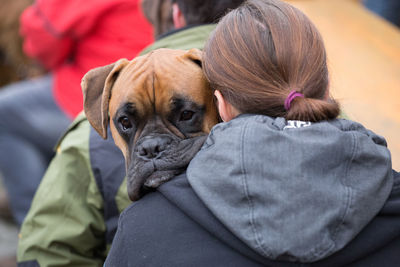 Rear view of a woman carrying her dog