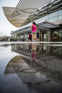 Rear view of woman walking on bridge